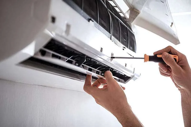 Man, an electrical technician working in a switchboard with fuses. Installation and connection of electrical equipment. Professional with tools in hand. concept of complex work, space for text.