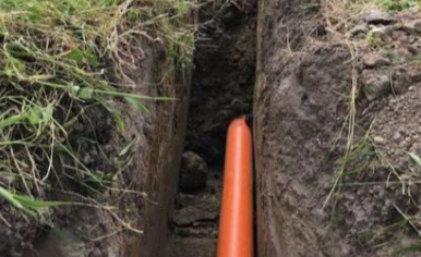 conduit running in an underground trench protects electrical cables